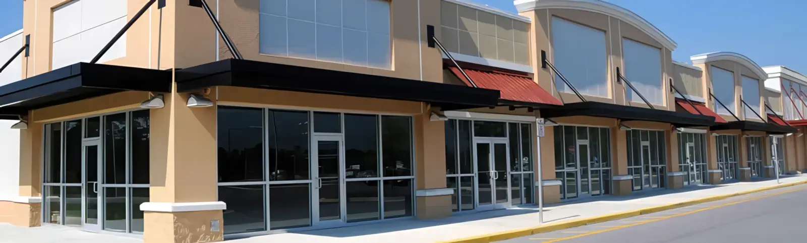 Commercial strip mall storefront with large windows — John Beal Roofing commercial roofing in Lebanon, MO