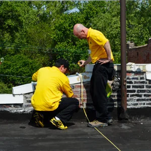 Two roofers inspecting and measuring a residential roof — John Beal Roofing roofing in Mexico, MO