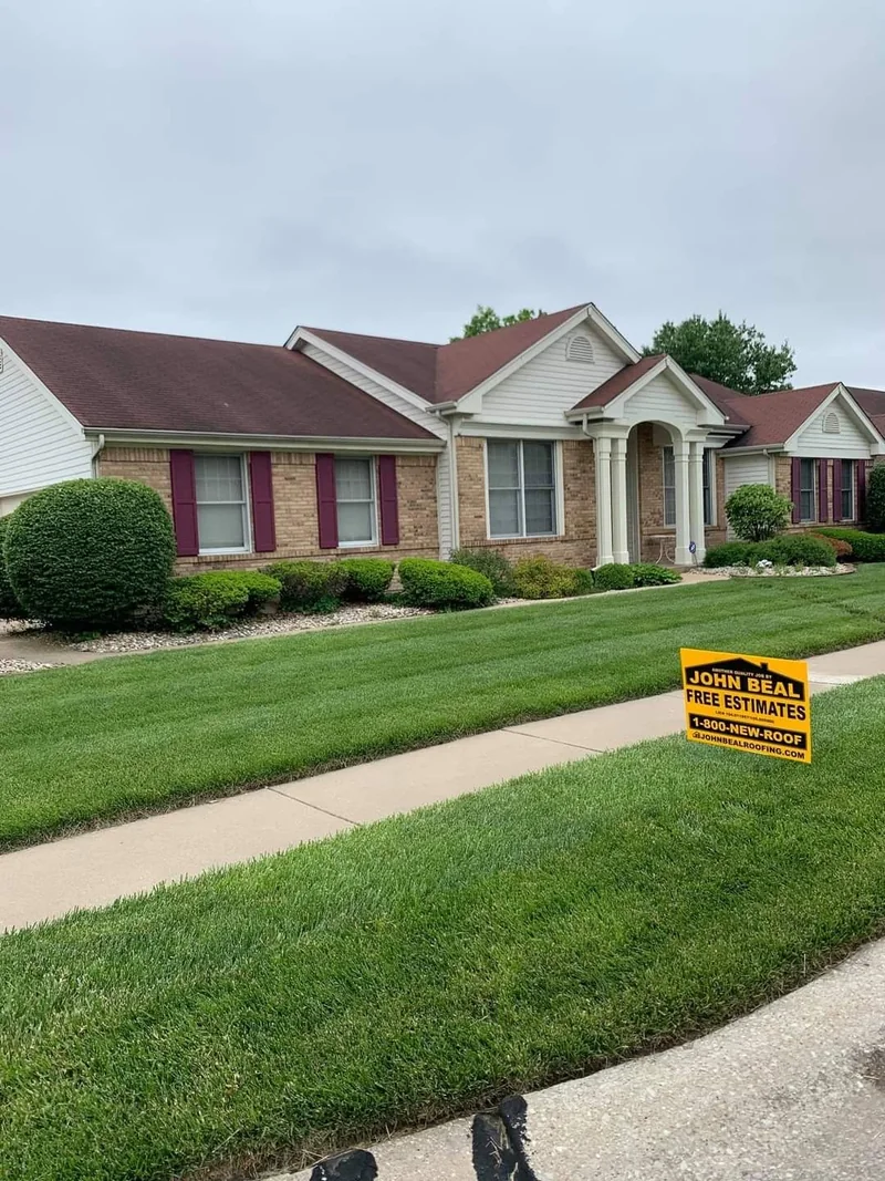 New roof on a brick ranch home with a John Beal Roofing yard sign