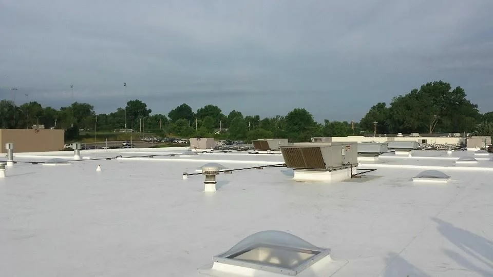 Commercial PVC membrane roof with kitchen exhaust and HVAC equipment serviced by John Beal Roofing