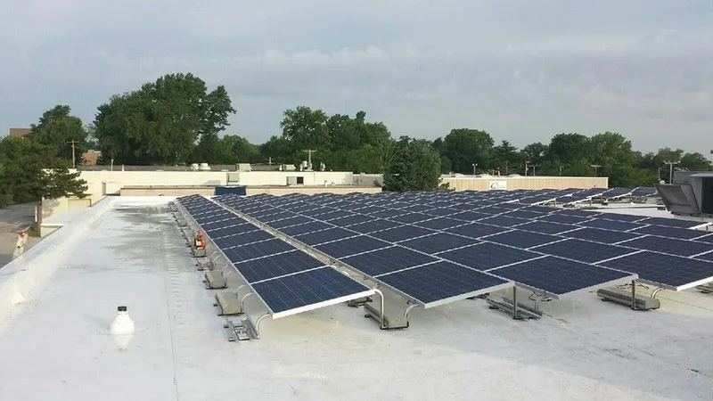 White low-slope commercial roof with a rooftop solar array on a John Beal Roofing project