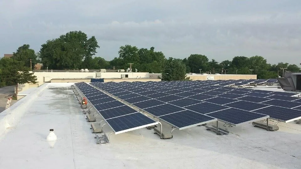 Commercial spray polyurethane foam low-slope roof with rooftop equipment serviced by John Beal Roofing