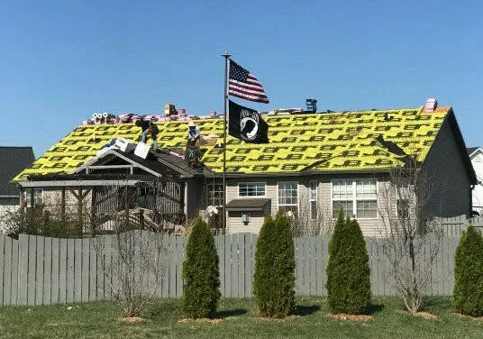 John Beal Roofing crew installing underlayment on a residential roof