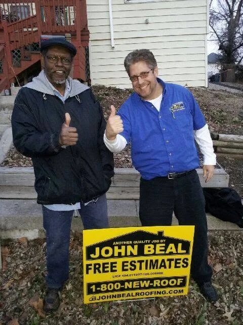 A John Beal Roofing rep and a happy customer giving a thumbs up after the job