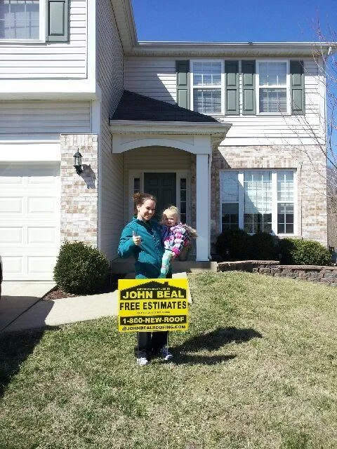 Mother and daughter with a John Beal yard sign outside their two-story home