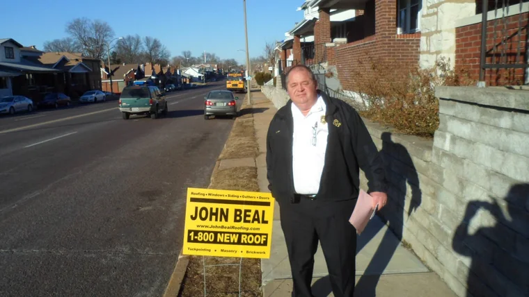 John Beal Roofing representative with a yard sign on a St. Louis city street