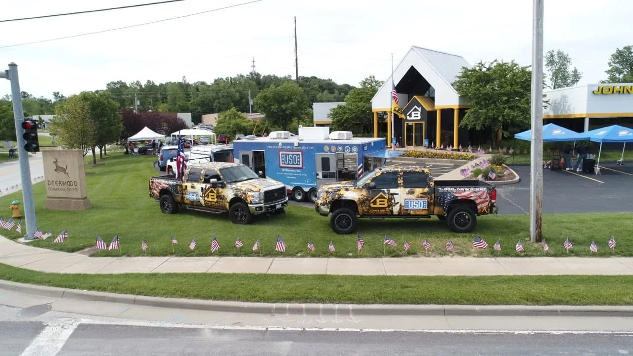 Aerial view of John Beal Roofing headquarters and fleet flying American flags
