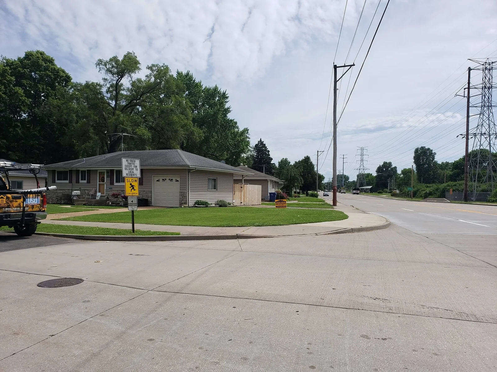 Corner-lot home with a finished John Beal Roofing replacement and yard sign