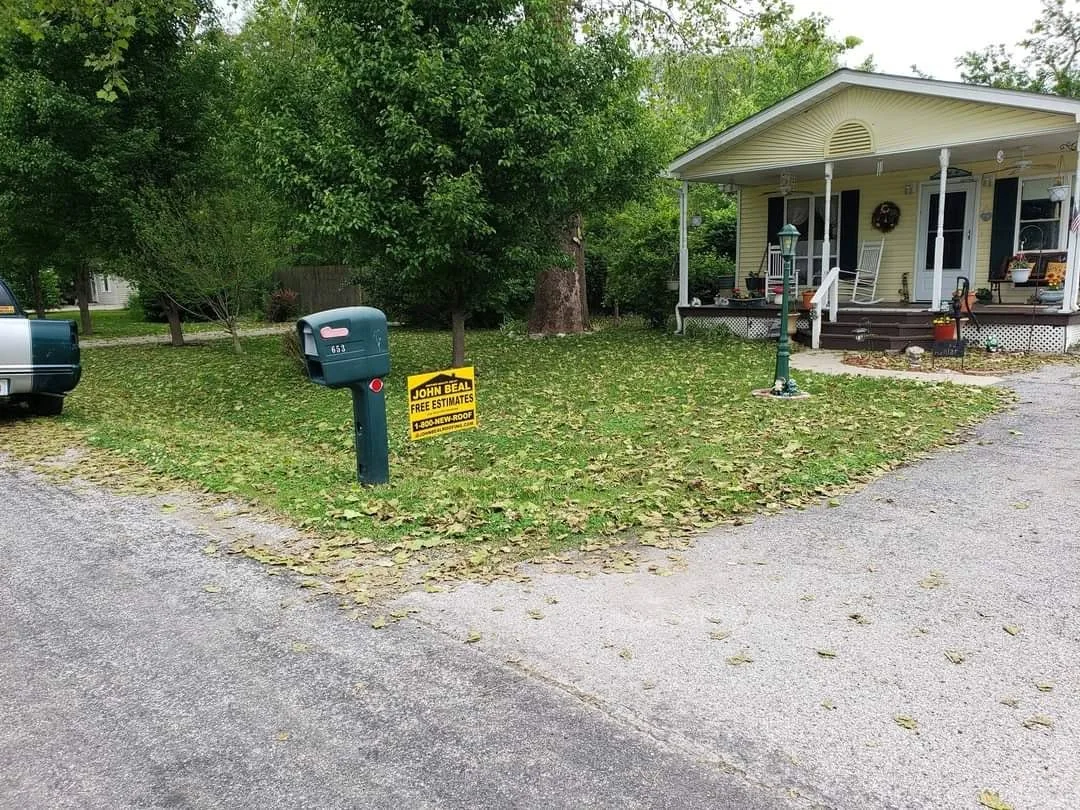 John Beal Roofing yard sign outside a completed residential roof replacement