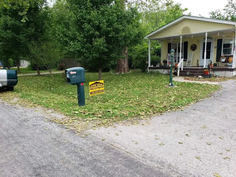 Completed John Beal Roofing roof replacement with yard sign