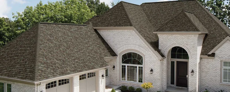 Architectural asphalt shingle roof in driftwood gray-brown on a white brick home — John Beal Roofing