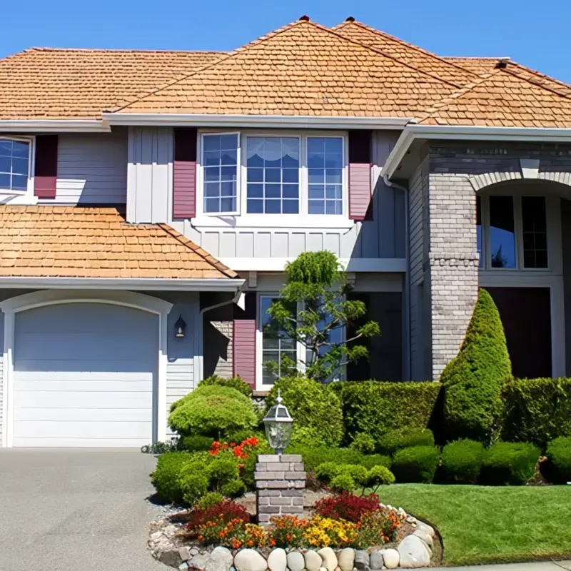 Suburban home with landscaping and an asphalt shingle roof — John Beal Roofing
