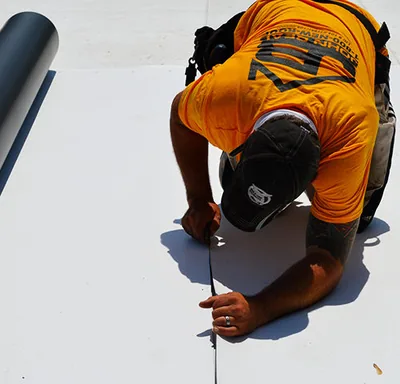 Roofer measuring and marking a flat commercial roof — John Beal Roofing commercial roofing in Eldon, MO