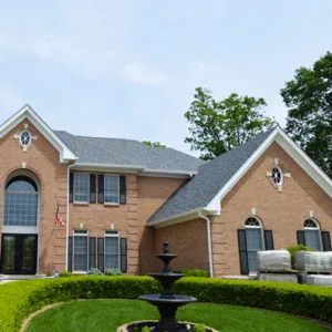 Two-story brick home with a landscaped front yard — John Beal Roofing roofing in Sparta, IL