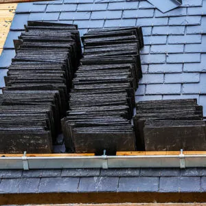 Stack of slate roofing tiles showing natural texture — John Beal Roofing roofing in Plainfield, IN