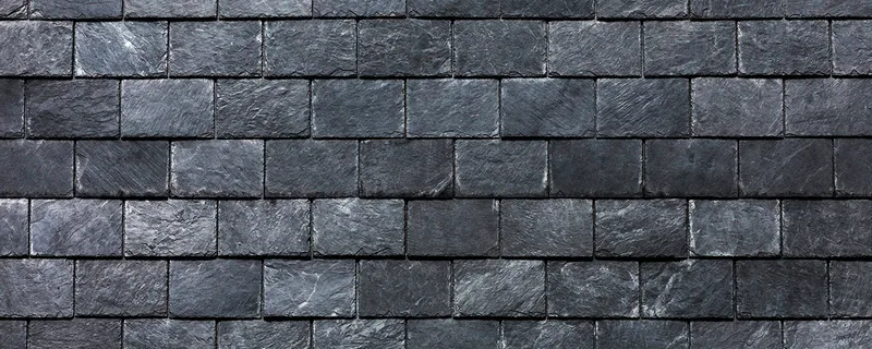 Close-up texture of dark grey natural slate roof tiles — John Beal Roofing gutter installation in Springfield, MO
