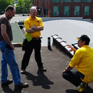Roofing contractors reviewing paperwork with a homeowner — John Beal Roofing roofing in Versailles, MO