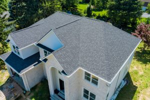 Two story home with gray shingle roof